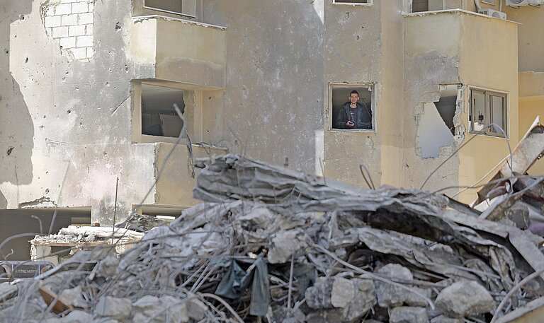 Ein Mann schaut aus dem Fenster eines zertrümmerten Hauses in Libanon