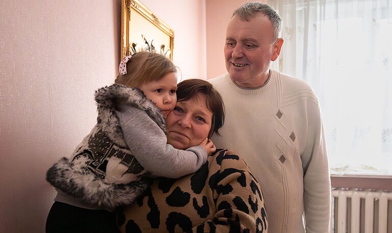 Yuri und Nadia zusammen mit eines ihrer Pflegekinder in den Armen in ihrem Haus
