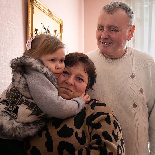 Yuri und Nadia zusammen mit eines ihrer Pflegekinder in den Armen in ihrem Haus