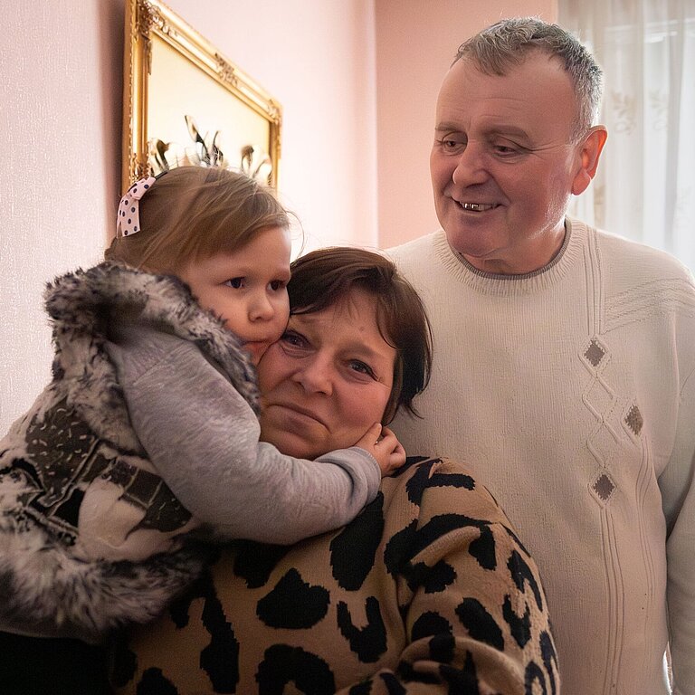 Yuri und Nadia zusammen mit eines ihrer Pflegekinder in den Armen in ihrem Haus