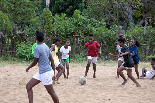 Beim Training Mädchen spielen Fußball im Sand
