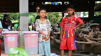 Kinder mit Hilfsgütern stehend 