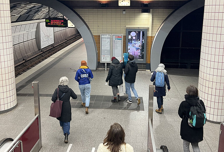 Menschen laufen Treppen hinunter in eine U-Bahn-Station.