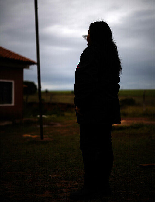 Eine Frau steht aus einem Feld und schaut in die Ferne