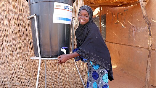 Ein Mädchen benutzt die Handwaschstation in ihrer Schule.