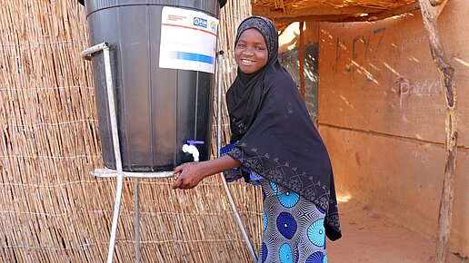 Ein Mädchen benutzt die Handwaschstation in ihrer Schule.