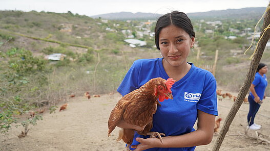Junge Frau mit Huhn im Arm in 