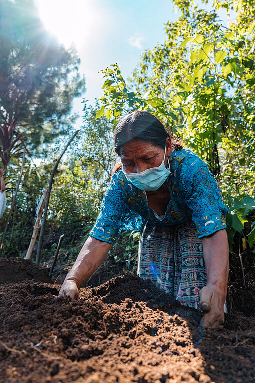 Plan International veranstaltet Schulungen zu Landwirtschaft und Viehzucht in Guatemala. Eine Frau buddelt in der Erde