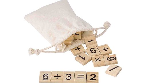 Mathe Lernspiel im Beutel Beutel aus dem mit Ziffern und Funktionszeichen bedruckte Plättchen scheuen. Eine Gleichung ist vorne zusammengesetzt.