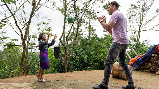 Christian Prokop und Chi Ra spielen draußen Handball.