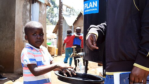 Zugang zu öffentlichen Wasserstationen ist für viele Familien überlebensnotswendig. Kind wäscht sich die Hände