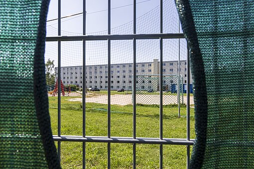 Blick durch einen Zaun auf einen Spielplatz