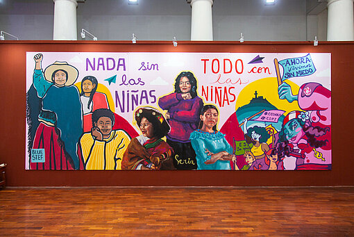 Ein Wandgemälde in einer Kunstgalerie, auf dem die Geschichte der Mädchenrechte in Peru graphisch dargestellt ist. Frauen in kämpferischen Posen und Schriftzüge sind zu sehen.