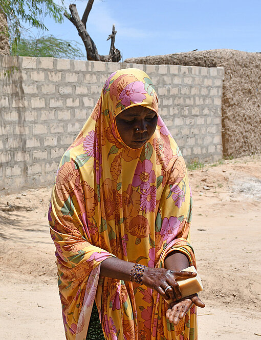 Eine Frau demonstriert, wie man sich die Hände mit Wasser und Seife wäscht