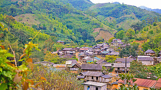In einem tief eingeschnittenen Tal in den grün bewaldeten Bergen von Zentral-Vietnam liegt ein kleines Dorf mit zum Teil traditionellen Häusern der ethnischen Minderheit Bru Van Kieu, Provinz Quang Tri