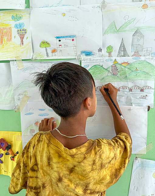 Ein kleiner Junge zeichnet ein Bild