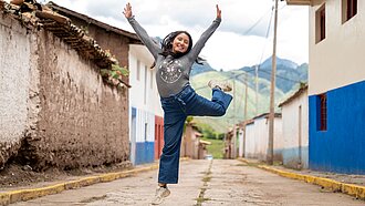 Eine junge Frau springt auf einem Bein in die Luft