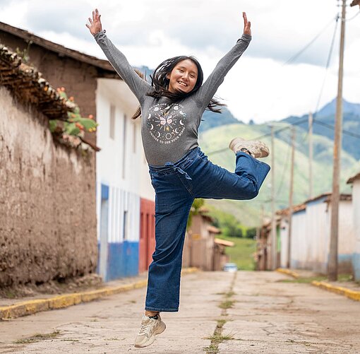 Eine junge Frau springt auf einem Bein in die Luft