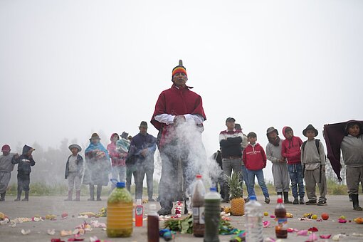 Inti Raymi Der weise Mann steht umringt von der Gemeinde auf einem Platz.