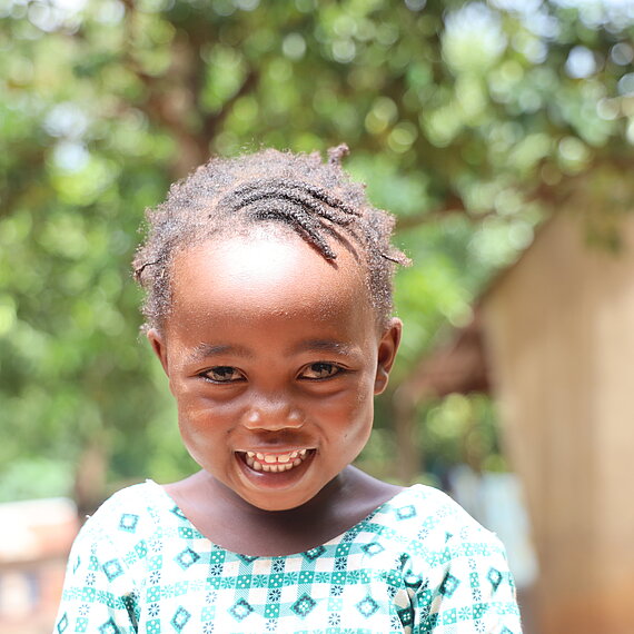 Ein kleines Kind grinst in die Kamera