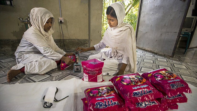 Danach packen die Mädchen die fertigen Binden zusammen in Päckchen. © Plan International