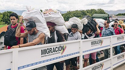 Mit Gütern beladen laufen Grenzgänger:innen zurück nach Venezuela. © Foto: Plan/Anika Büssemeier