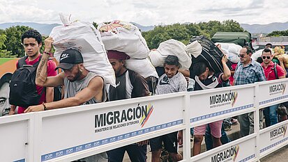 Mit Gütern beladen laufen Grenzgänger:innen zurück nach Venezuela. © Foto: Plan/Anika Büssemeier Mit Gütern beladen laufen Grenzgänger:innen zurück nach Venezuela. © Foto: Plan/Anika Büssemeier