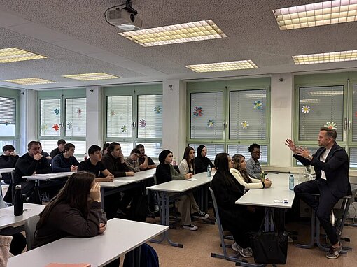 Gregor Schütz spricht mit den Projektteilnehmenden im Klassenraum