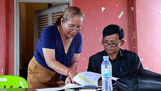 Sohen und ein Kollege lesen einen Bericht zum Thema Kinderschutz und besprechen diesen