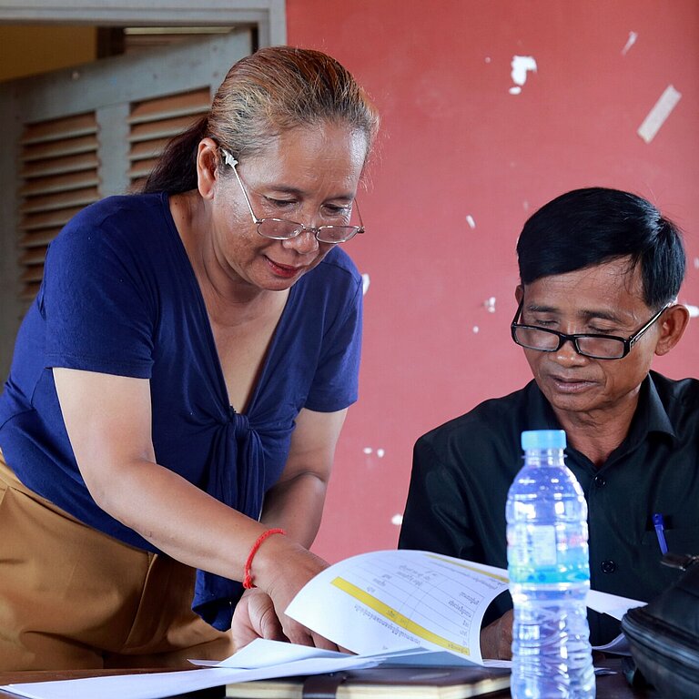 Sohen und ein Kollege lesen einen Bericht zum Thema Kinderschutz und besprechen diesen