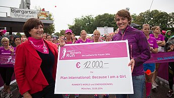 Stephanie Fahnemann (r.) überreicht Christa Stewens vom Plan-Kuratorium einen Scheck über 12.000 Euro für den Mädchen-Fonds.