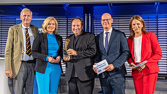 Fünf Personen stehen nebeneinander auf einer Bühne