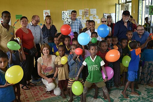 Unsere mitgebrachten Luftballons kommen sehr gut an bei den Kindern. Pat:innen und Schulklasse mit Luftballons.