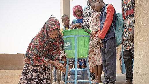 Assiatou, 9, wäscht ihre Hände vor dem Mittagessen. 