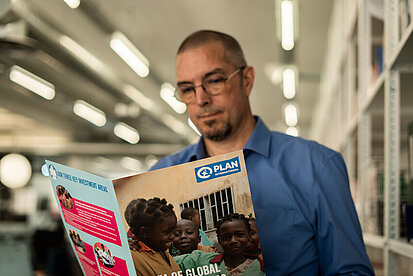 Mann liest Plan-Magazin.