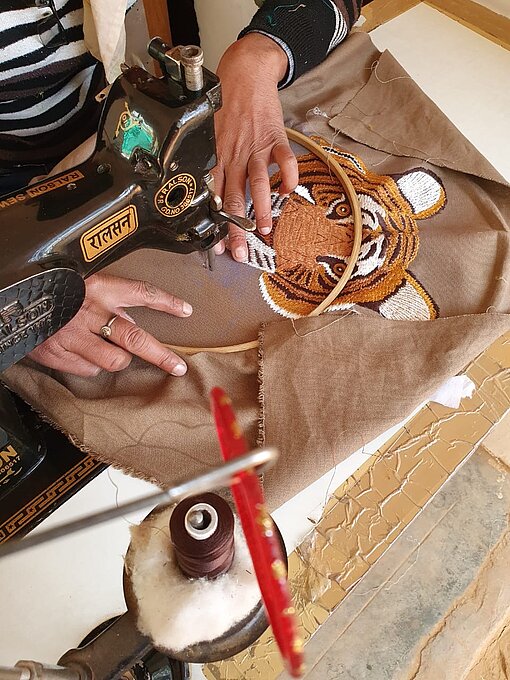 Eine handgemachte Ranger-Jacke wird mit einem Tiger-Motiv bestickt Eine handgemachte Ranger-Jacke wird mit einem Tiger-Motiv bestickt