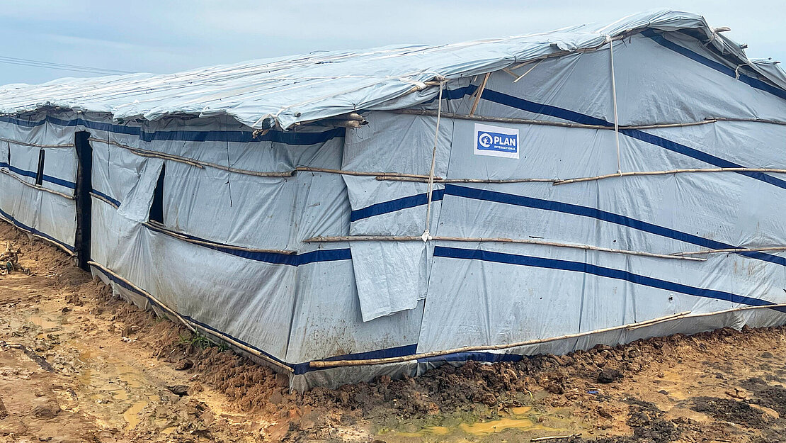 Ein Shelter von außen Eine etwa 30 Meter langes und 15 Meter breites Zelt, das einen kleinen Eingang hat