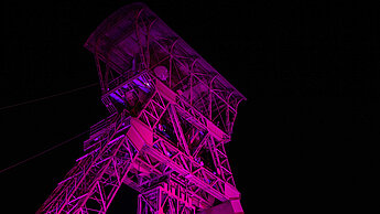 Der Fördertum in Moers ist in leuchtendem pink erleuchtet.