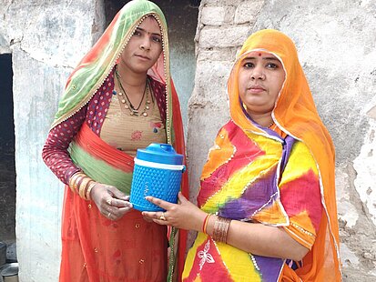 Zwei Frauen halten eine Nahrungsmittelration