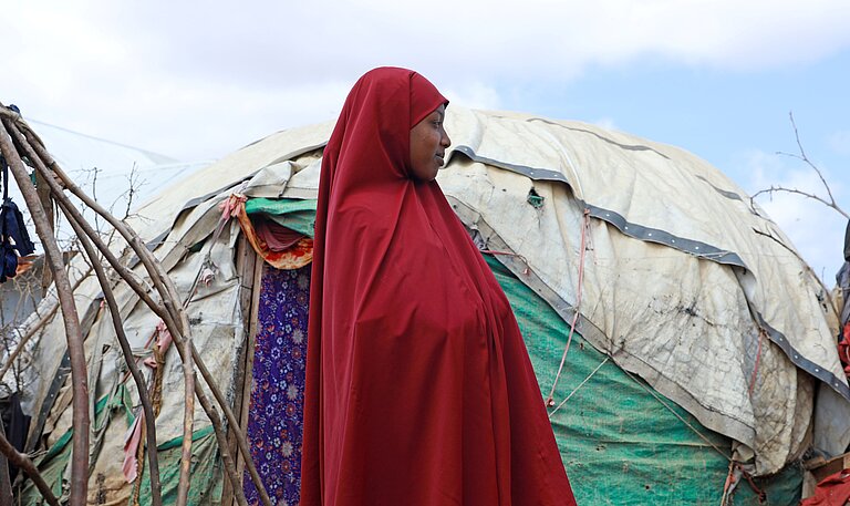 Hibo steht vor ihrem Zelt im IDP Camp