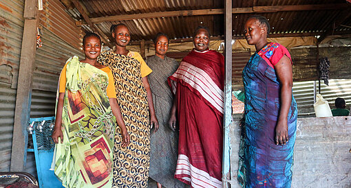 Fünf Frauen stehen in prächtigen Gewändern beisammen