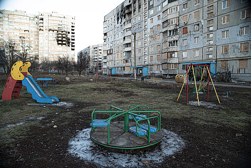 Raketenangriffe haben in einigen Städten der Ukraine ganze Häuserblöcke zerstört Ein leerer Spielplatz vor zerstörten Häusern