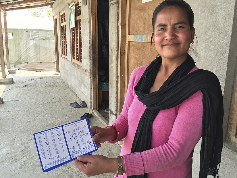 Head teachers Bidhaya shows the sign language card that teaches students how to sign