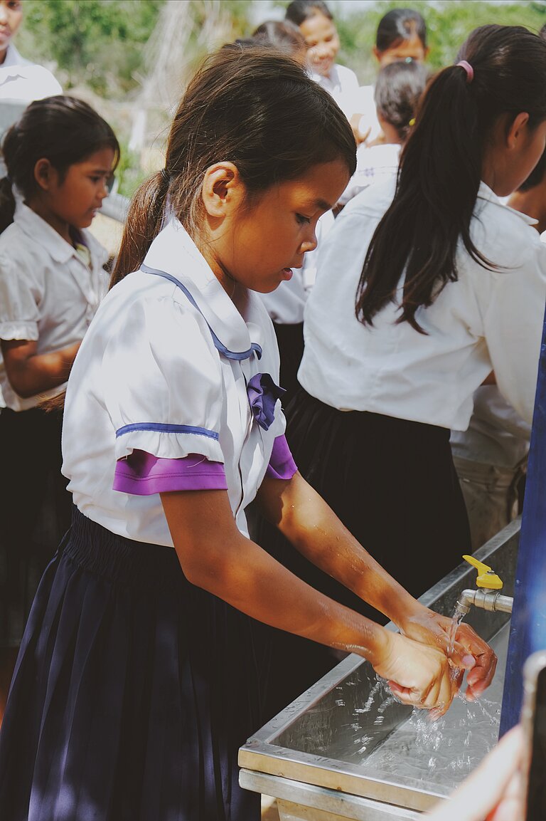 Schulmädchen wäscht sich die Hände.