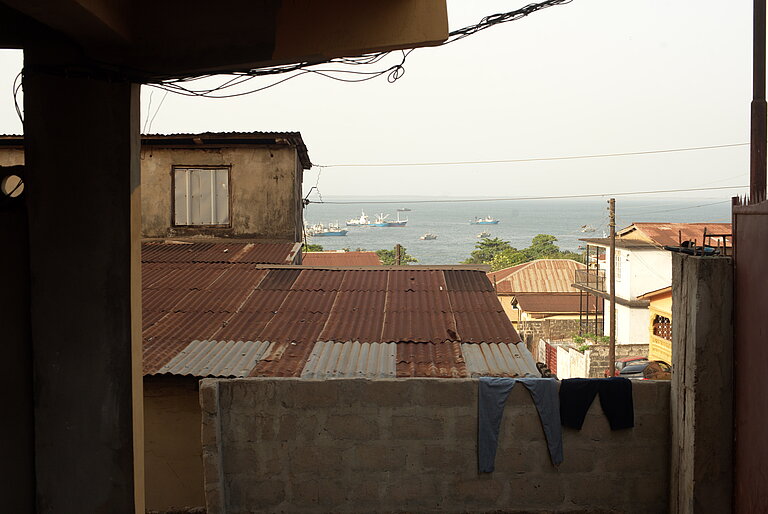 Blick über Häuserdächer von Freetown und das Meer