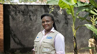Christine steht draußen in der Gemeinde in Uganda