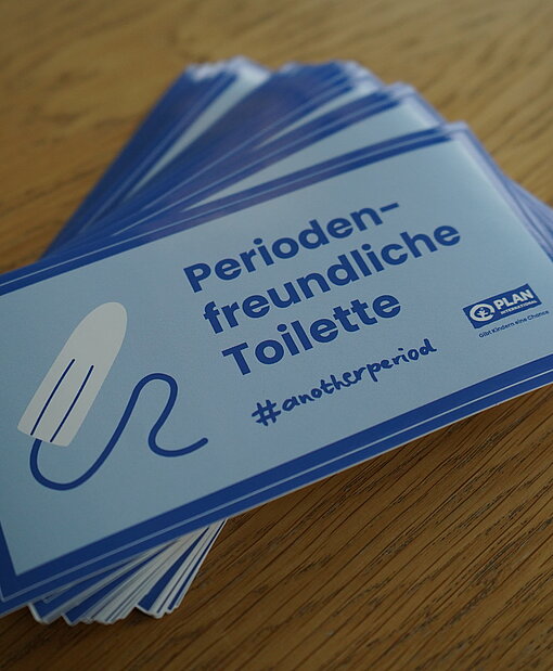 Sticker zur Kampagne „Another Period is possible“ Ein Stapel Sticker mit dem Aufdruck "Periodenfreundliche Toilette"