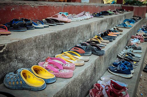 Schuhe aus, bevor in Kambodscha ein Raum betreten wird. Auch vor dem Klassenzimmer Schuhe stehen ordentlich auf einer Treppe