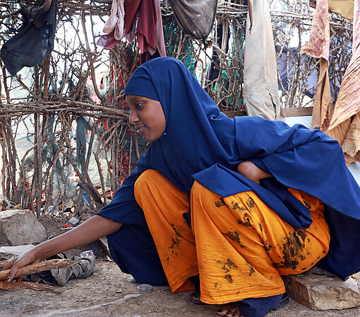 Aisha in ihrem Zelt in Baidoa bereitet eine Mahlzeit zu