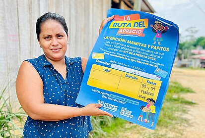 Eine Frau hält ein Projektplakat in den Händen